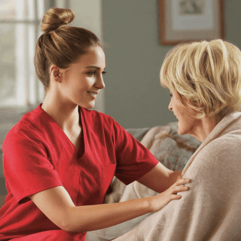 Friendly caregiver providing companionship and emotional support to an elderly person at home.